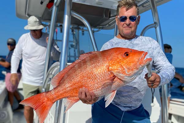 man holding a large orange fish