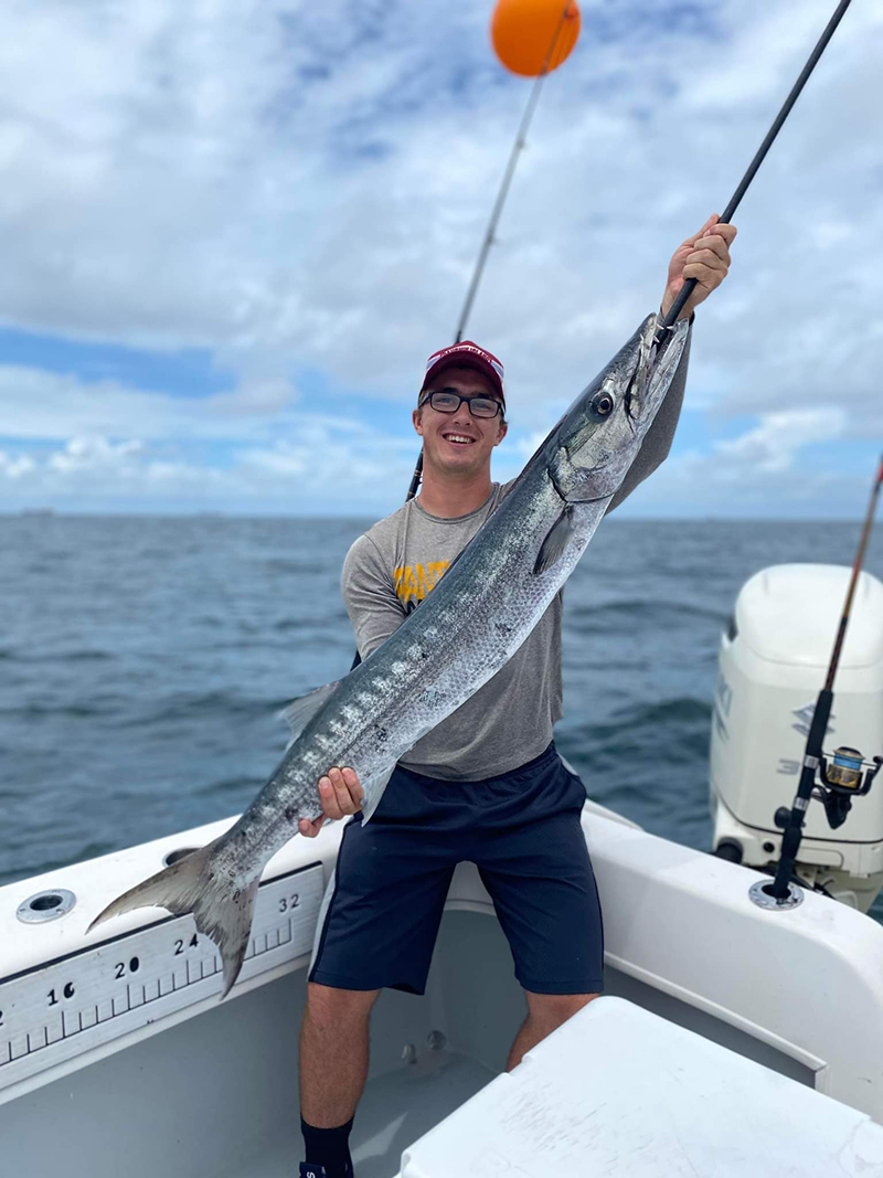 Anglers landing big fish offshore near Dauphin Island, fishing boats and Gulf waters
